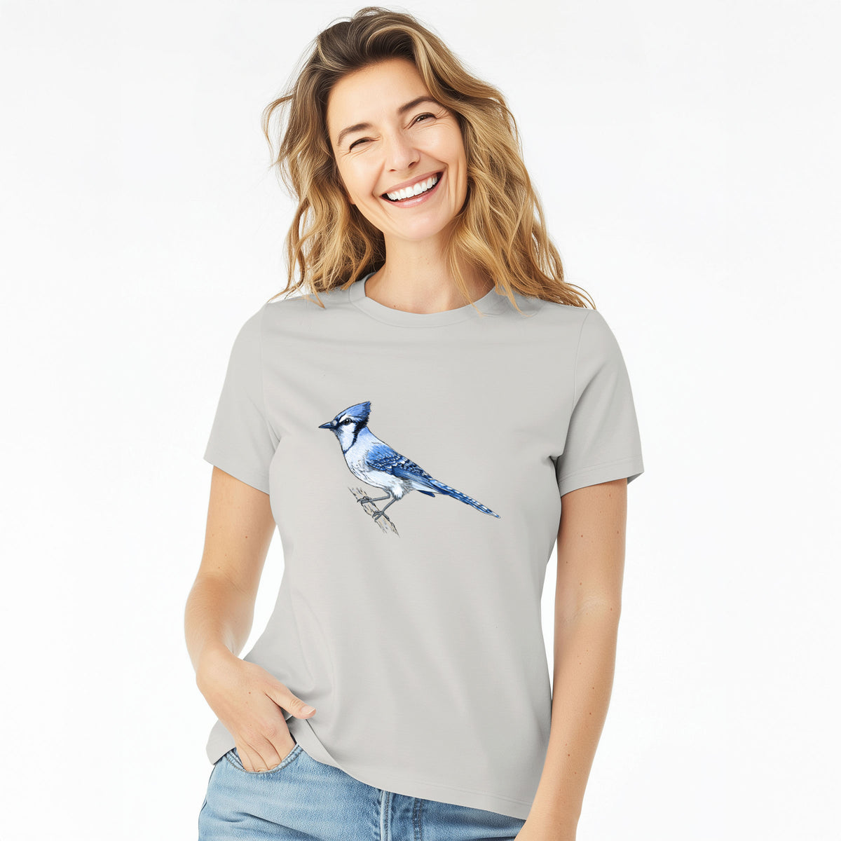 Woman wearing a lunar grey women's relaxed fit cotton t-shirt printed with a full-color illustration of a blue jay perched on a branch.