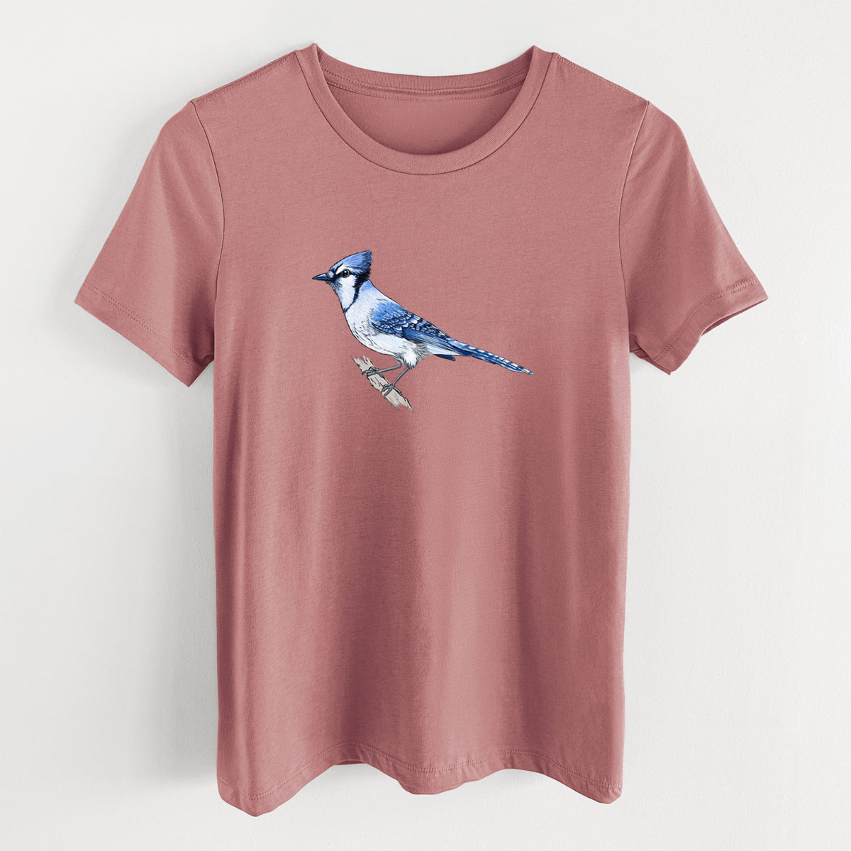Mauve pink women's relaxed fit cotton t-shirt laid flat, printed with a full-color illustration of a blue jay perched on a branch.