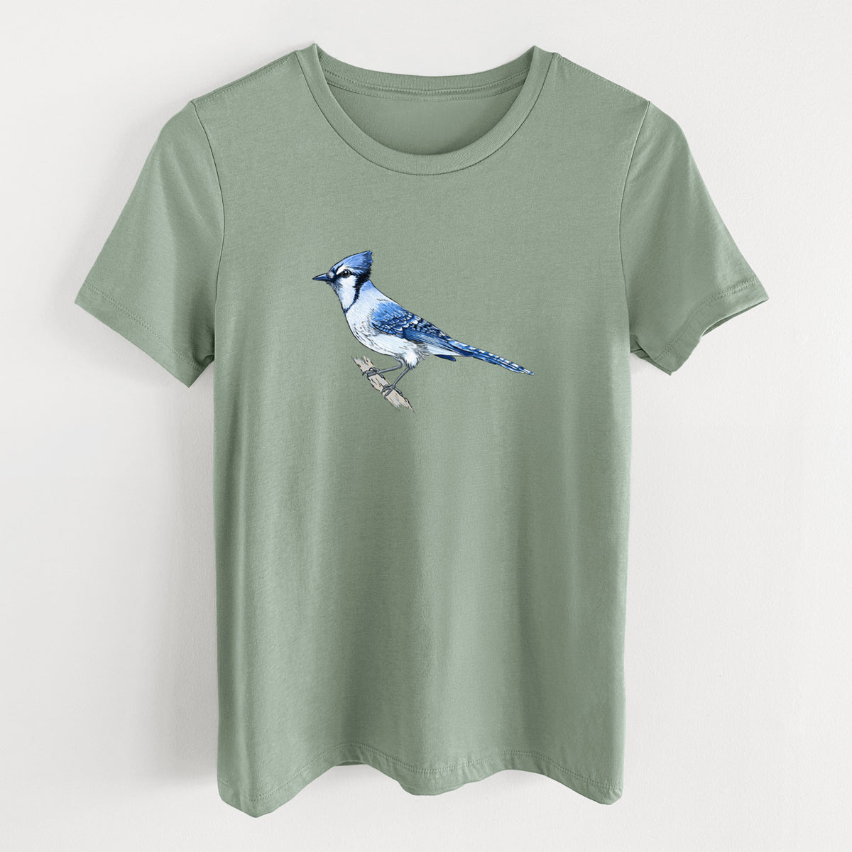 Sage green women's relaxed fit cotton t-shirt laid flat, printed with a full-color illustration of a blue jay perched on a branch.