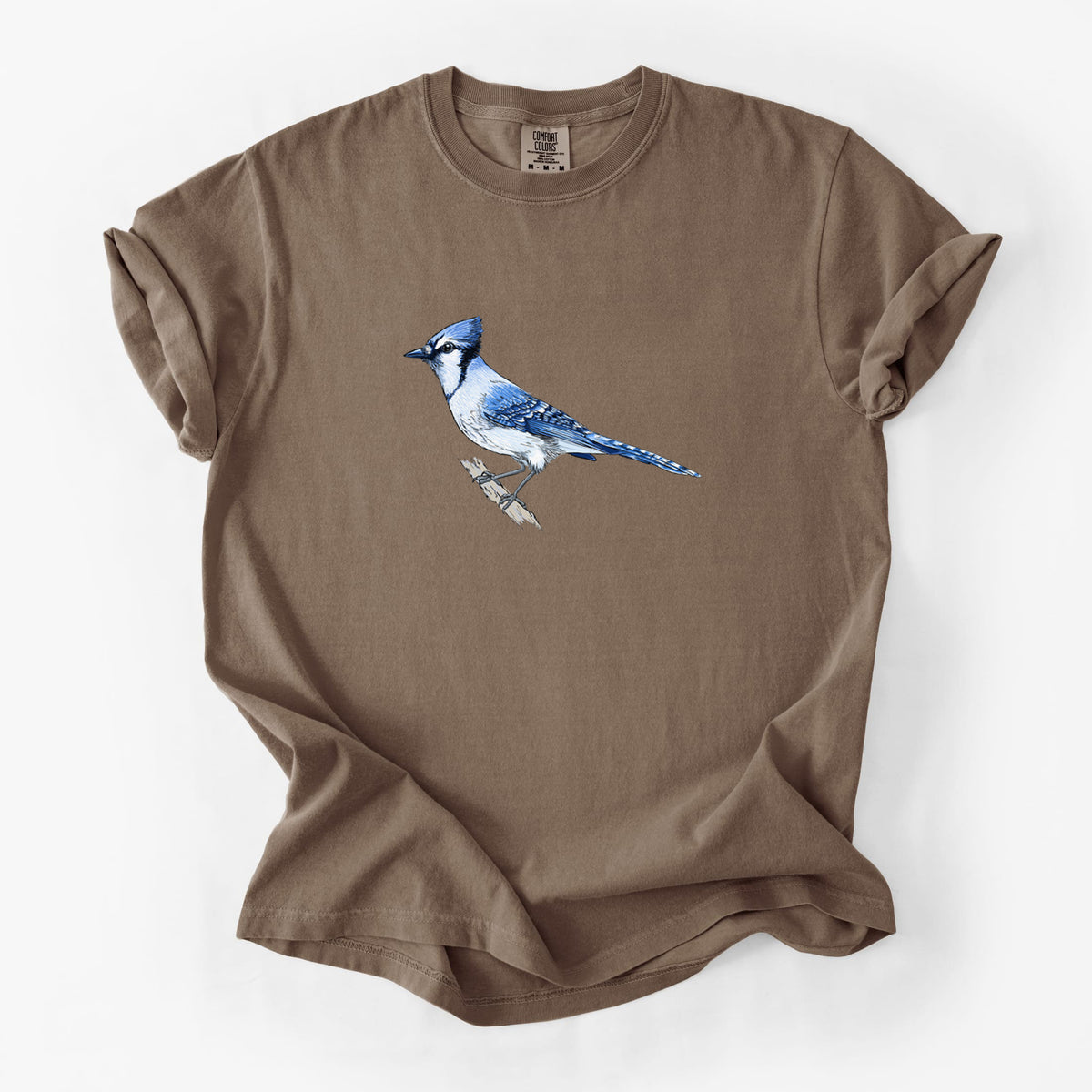 Espresso brown Comfort Colors t-shirt laid flat, printed with a full-color illustration of a blue jay perched on a branch.