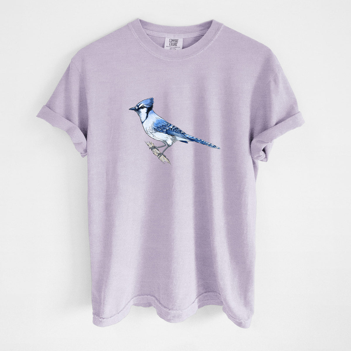 Orchid purple Comfort Colors t-shirt laid flat, printed with a full-color illustration of a blue jay perched on a branch.