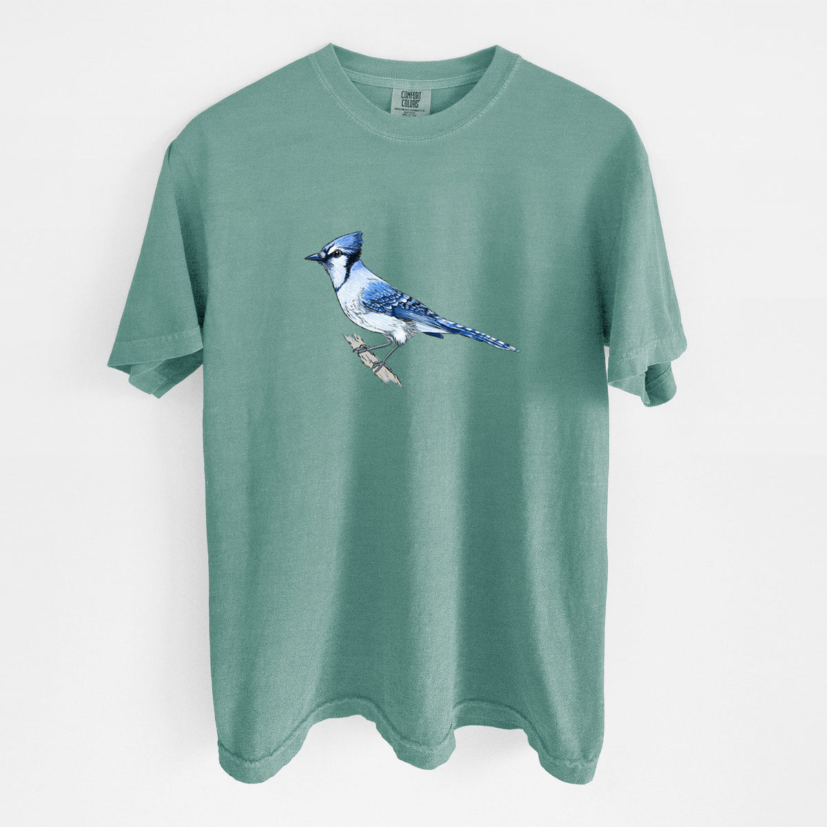 Reef green Comfort Colors t-shirt laid flat, printed with a full-color illustration of a blue jay perched on a branch.