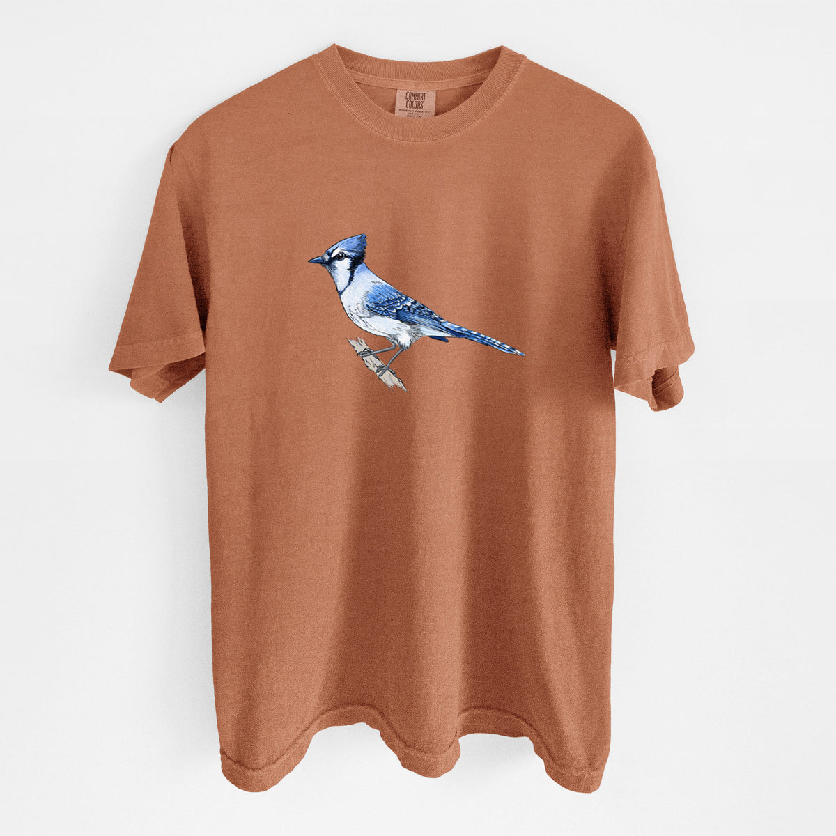 Yam burnt orange Comfort Colors t-shirt laid flat, printed with a full-color illustration of a blue jay perched on a branch.