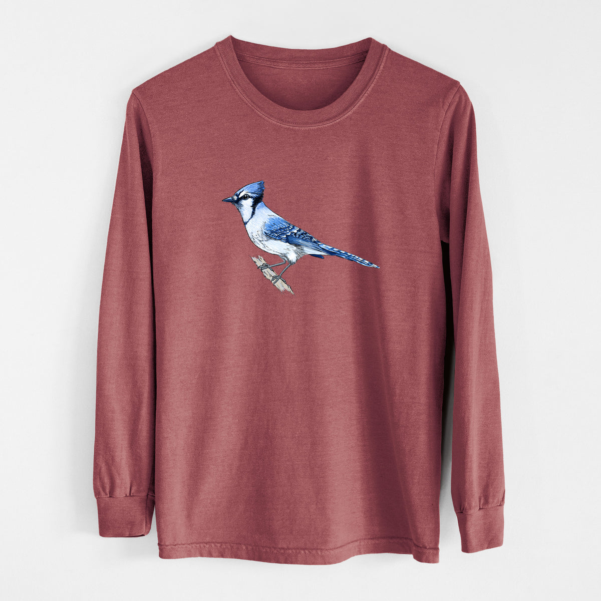 Brick red Comfort Colors long sleeve shirt laid flat, printed with a full-color illustration of a blue jay perched on a branch.