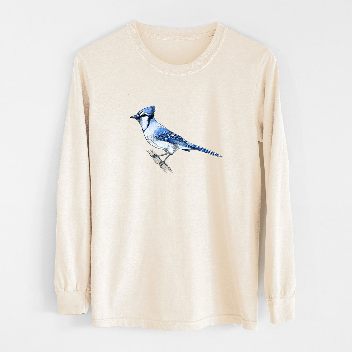 Ivory Comfort Colors long sleeve shirt laid flat, printed with a full-color illustration of a blue jay perched on a branch.