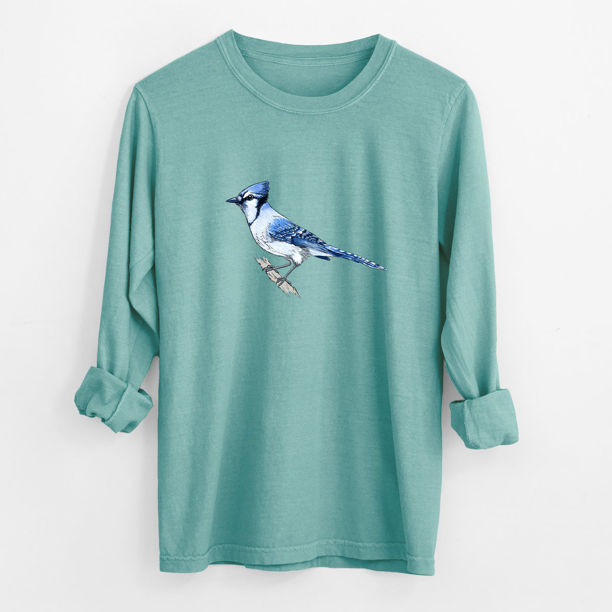 Reef green Comfort Colors long sleeve shirt laid flat with the cuffs rolled, printed with a full-color illustration of a blue jay perched on a branch.