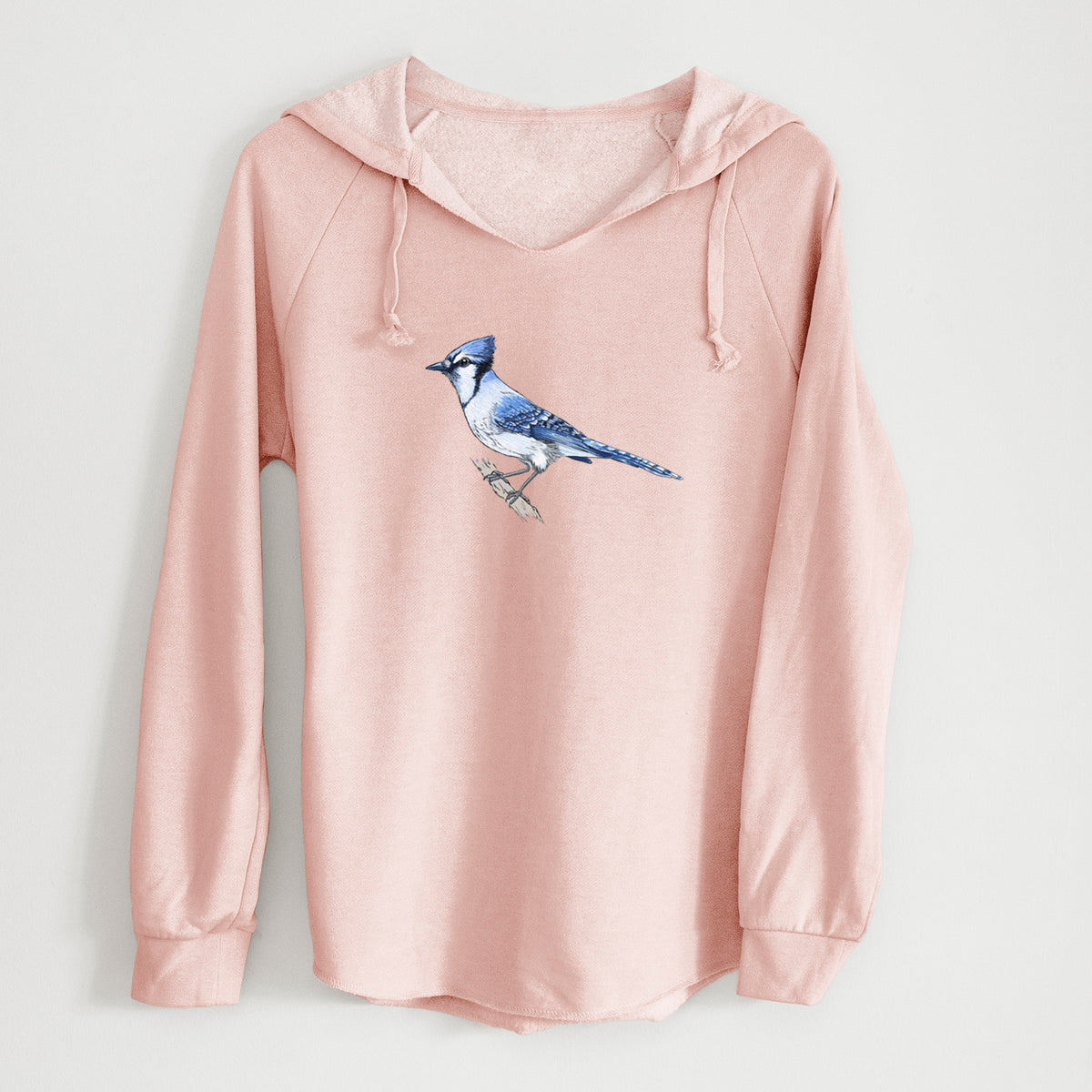 Blush pink women's Cali Wave hooded sweatshirt laid flat, printed with a full-color illustration of a blue jay perched on a branch.