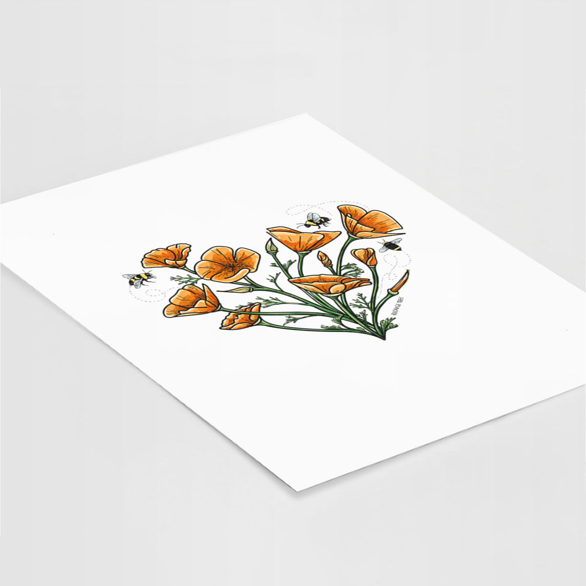 Art print of a full-color bouquet of orange California poppies arranged in a heart shape, with small bees, lying at an angle on a white surface.