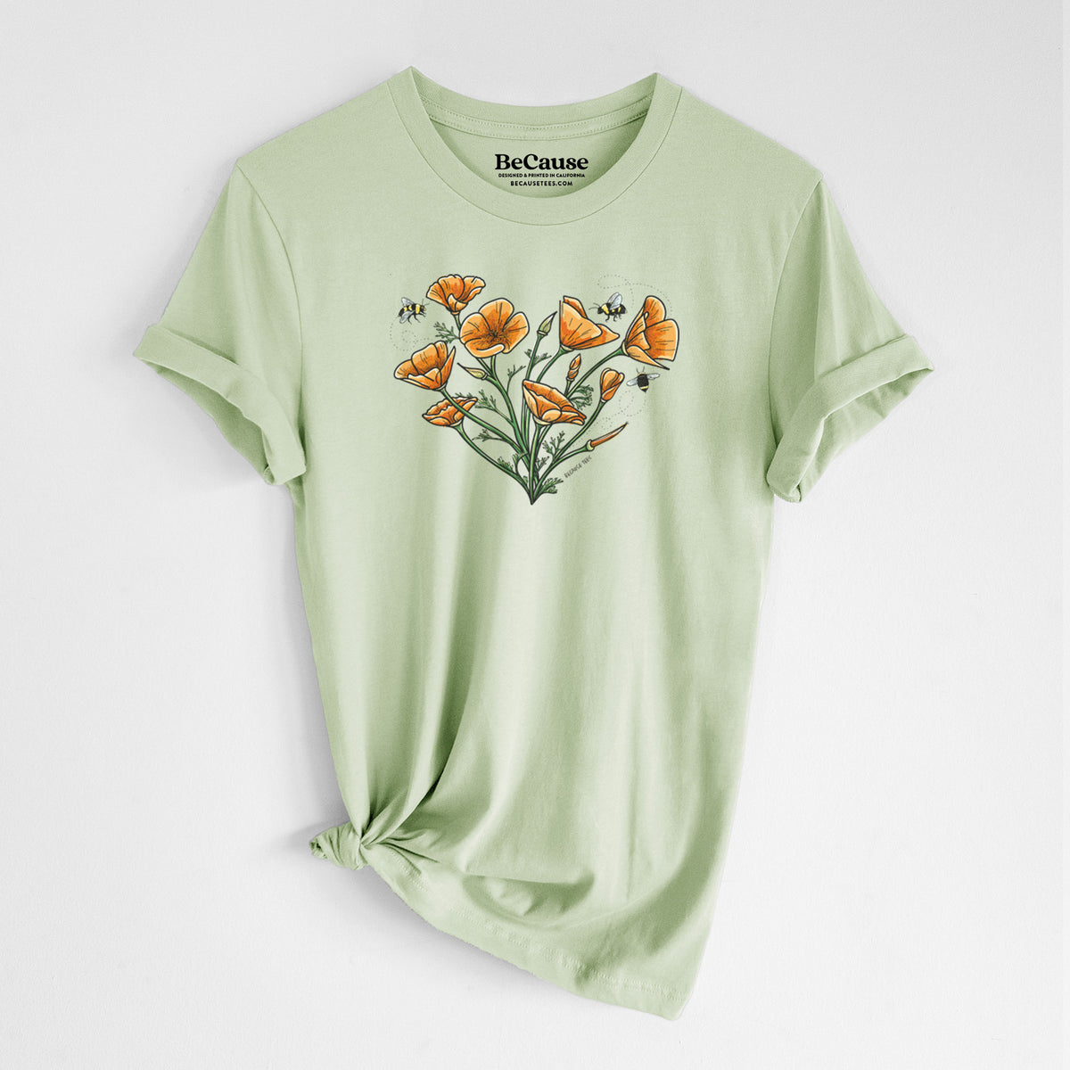 Spring green lightweight cotton t-shirt laid flat with the sleeves rolled, printed with a full-color bouquet of orange California poppies arranged in a heart shape, with small bees.