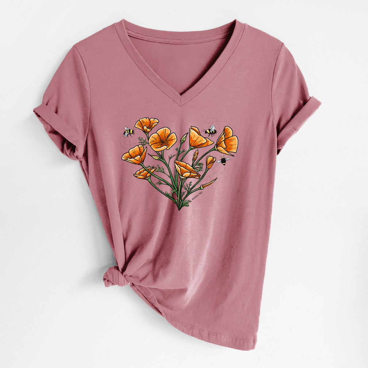 Mauve pink women's relaxed fit cotton V-neck t-shirt laid flat, printed with a full-color bouquet of orange California poppies arranged in a heart shape, with small bees.