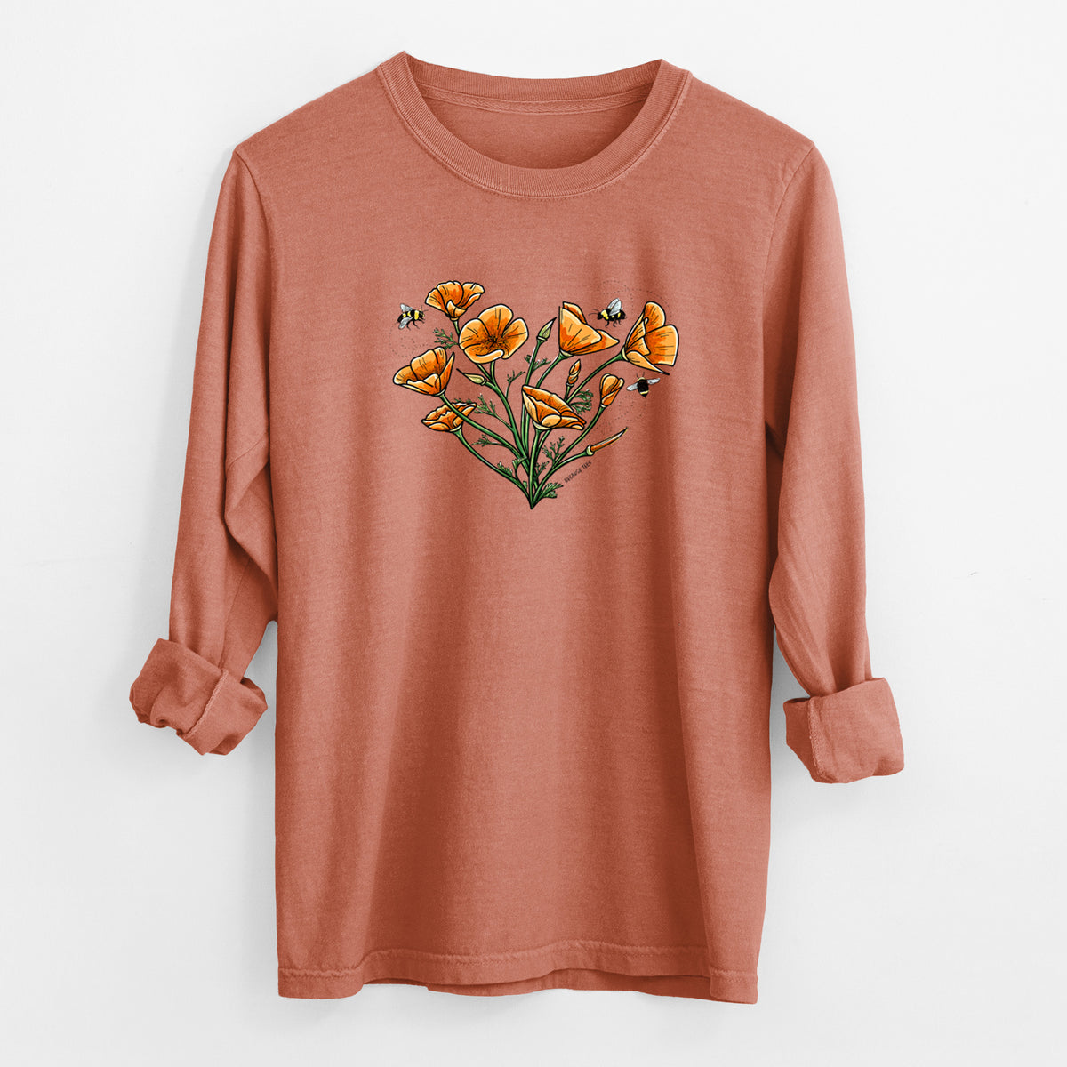 Yam burnt orange Comfort Colors long sleeve shirt laid flat with the cuffs rolled, printed with a full-color bouquet of orange California poppies arranged in a heart shape, with small bees.