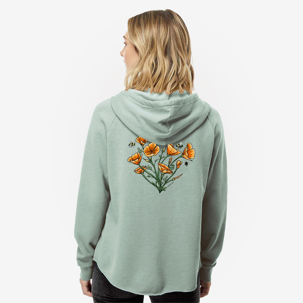 Woman wearing a sage green women's Cali Wave zip-up sweatshirt printed with a full-color bouquet of orange California poppies arranged in a heart shape, with small bees, seen from behind.