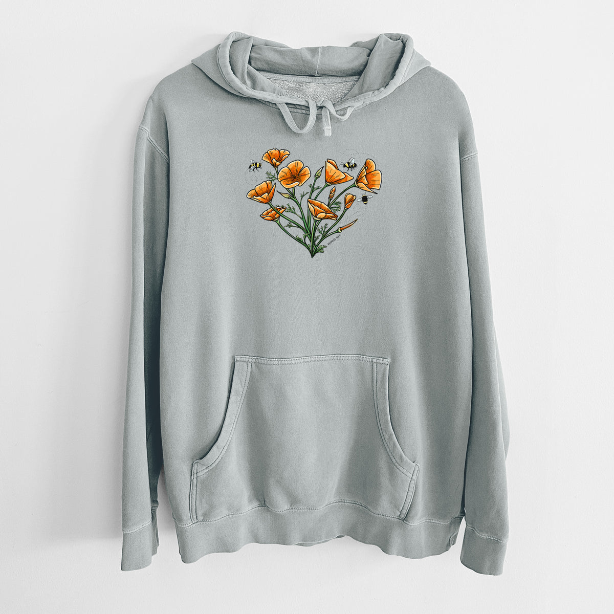 Sage green pigment dyed hoodie laid flat, printed with a full-color bouquet of orange California poppies arranged in a heart shape, with small bees.