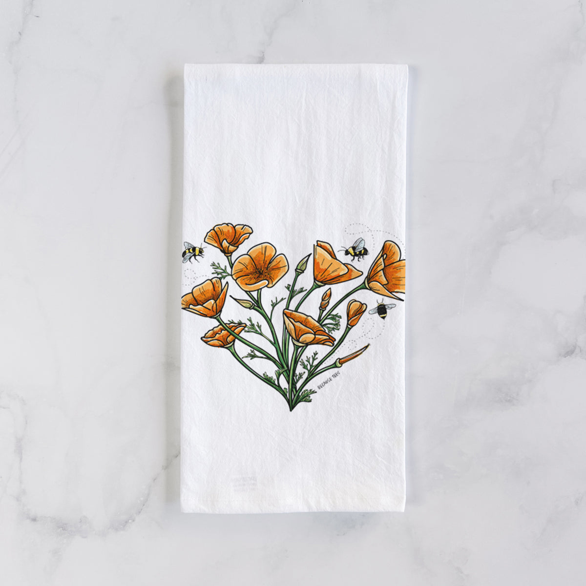 White cotton tea towel laid flat on marble, printed with a full-color bouquet of orange California poppies arranged in a heart shape, with small bees.