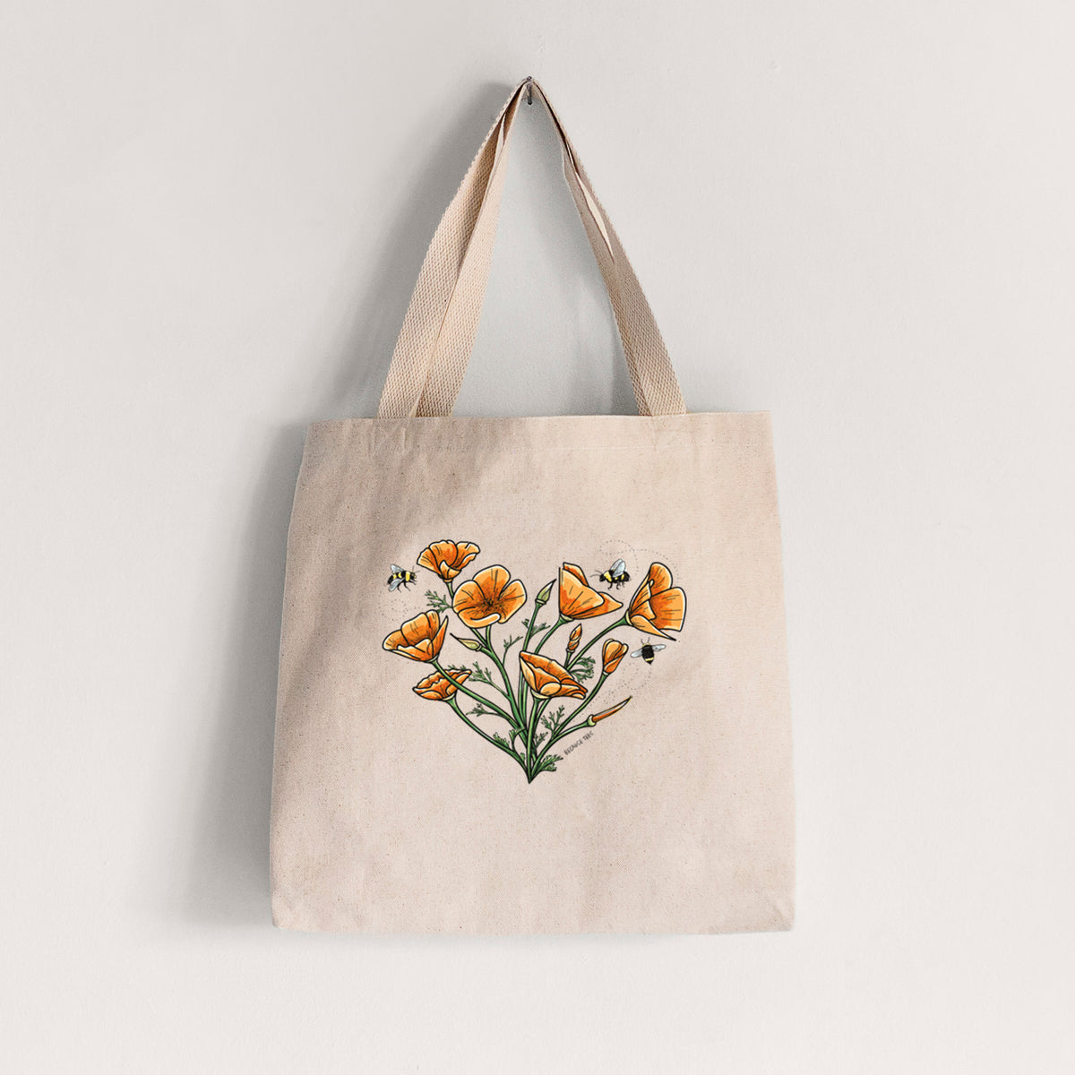 Natural canvas tote bag printed with a full-color bouquet of orange California poppies arranged in a heart shape, with small bees.