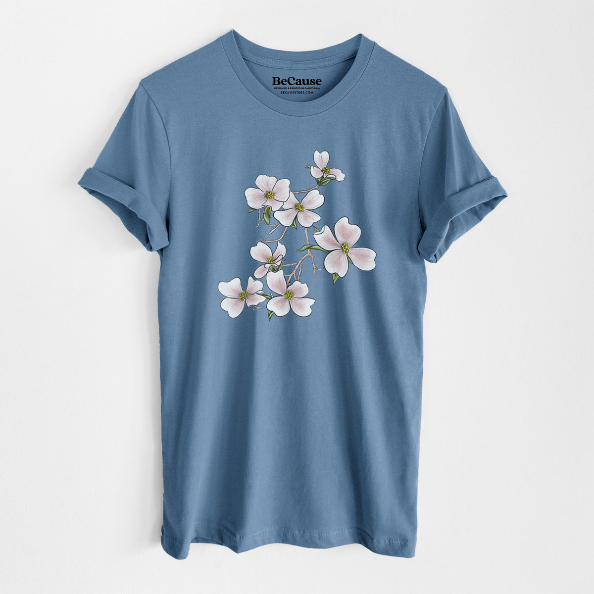 Steel blue lightweight cotton t-shirt laid flat, printed with a full-color illustration of pink and white dogwood blossoms on a branch.