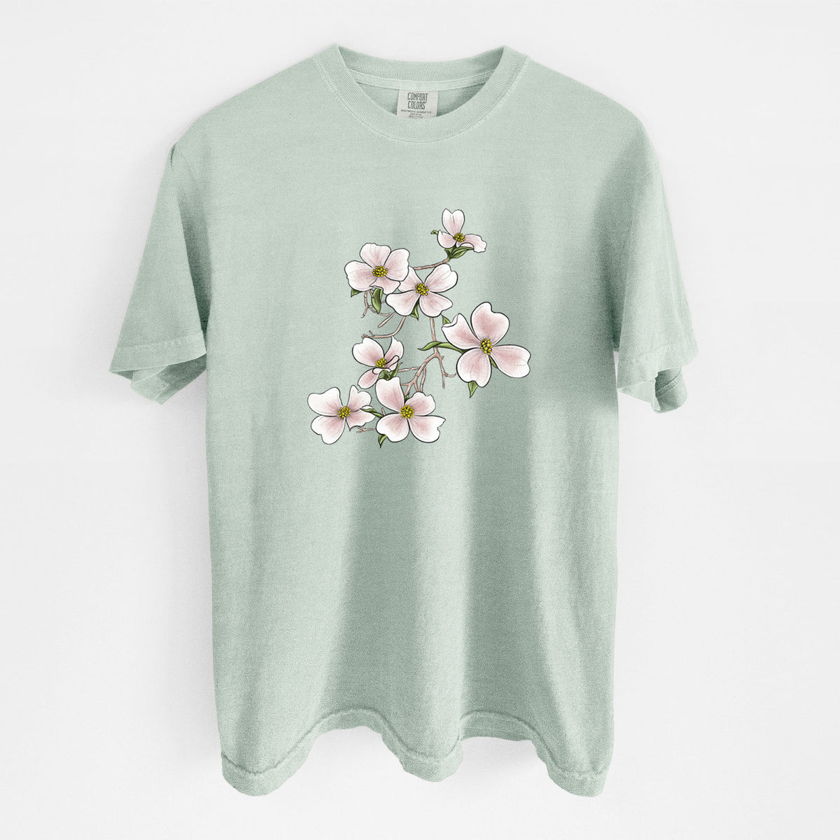 Bay green Comfort Colors t-shirt laid flat, printed with a full-color illustration of pink and white dogwood blossoms on a branch.
