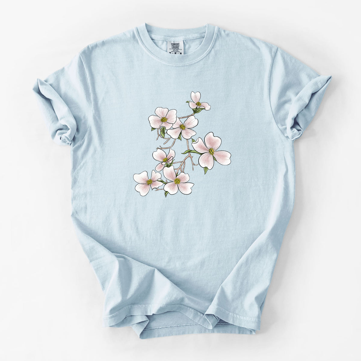 Chambray blue Comfort Colors t-shirt laid flat, printed with a full-color illustration of pink and white dogwood blossoms on a branch.