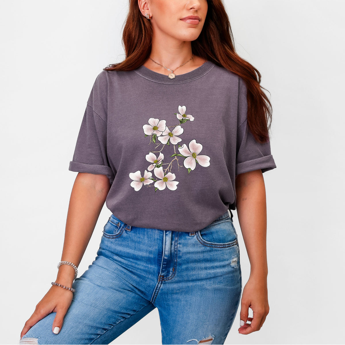 Woman wearing a Comfort Colors t-shirt printed with a full-color illustration of pink and white dogwood blossoms on a branch.