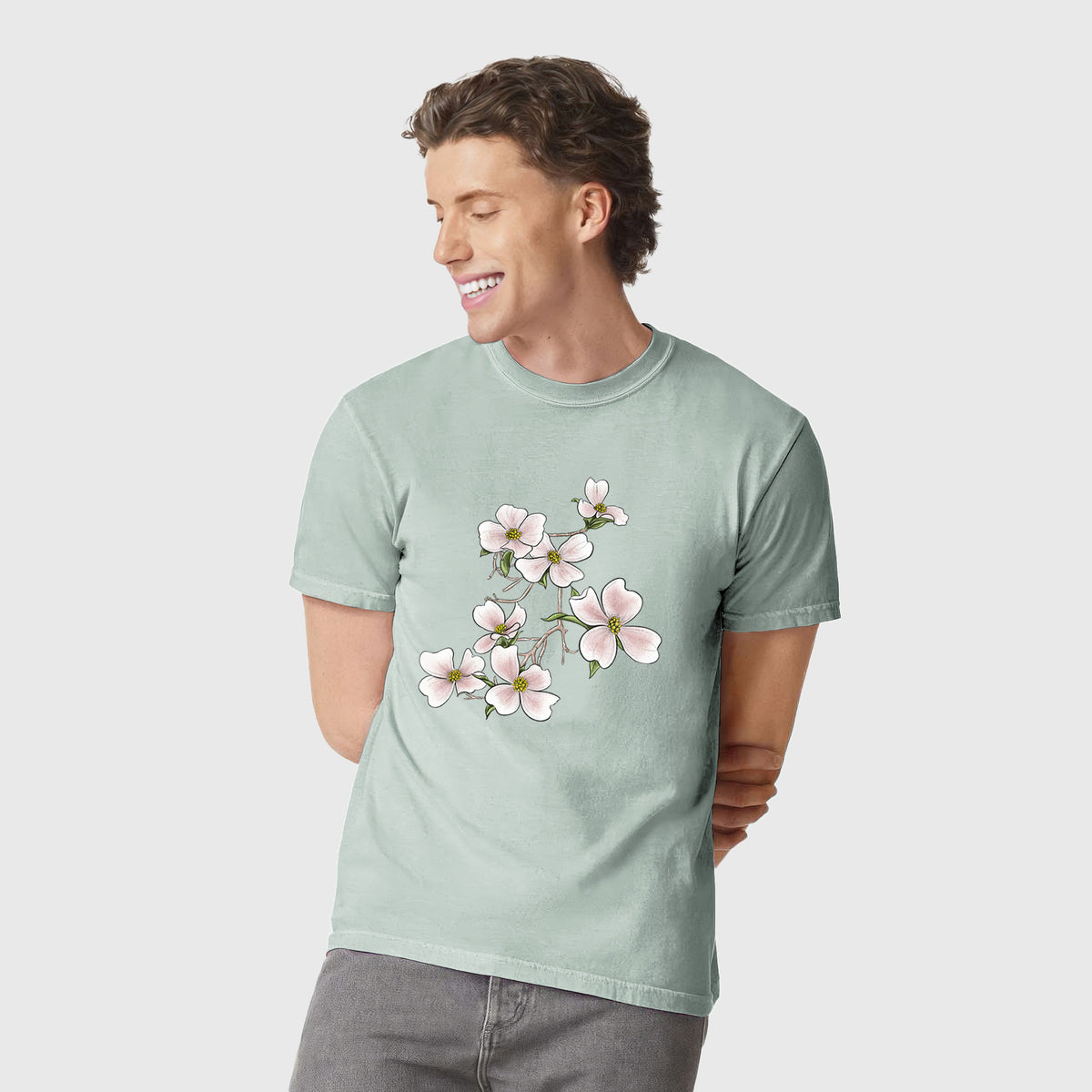 Man wearing a Comfort Colors t-shirt printed with a full-color illustration of pink and white dogwood blossoms on a branch.