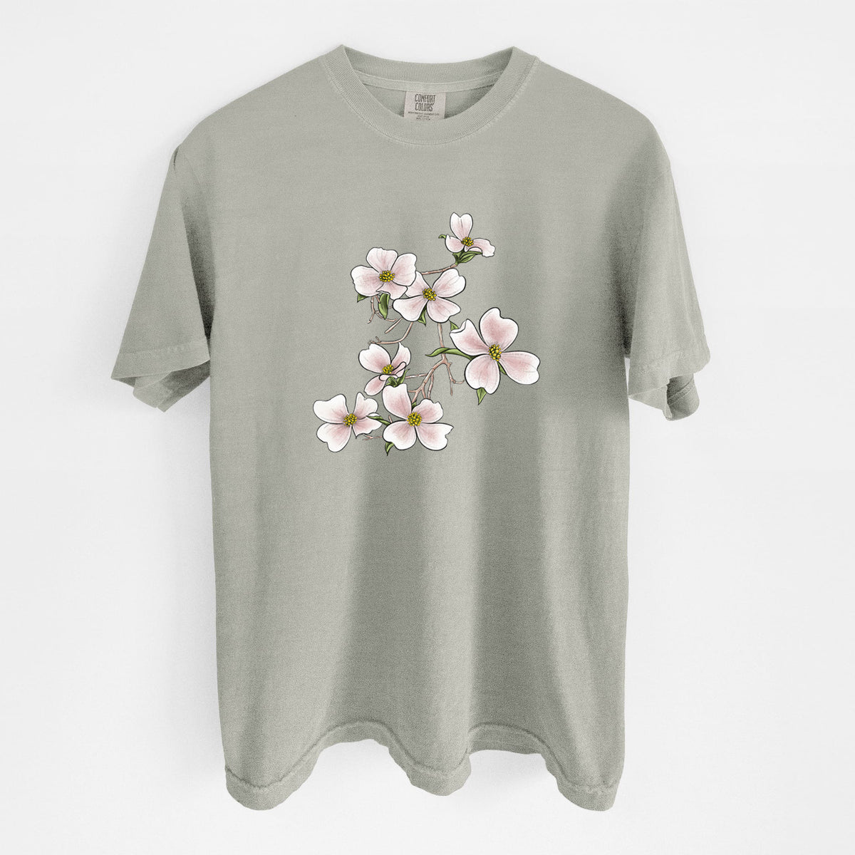 Sandstone beige Comfort Colors t-shirt laid flat, printed with a full-color illustration of pink and white dogwood blossoms on a branch.