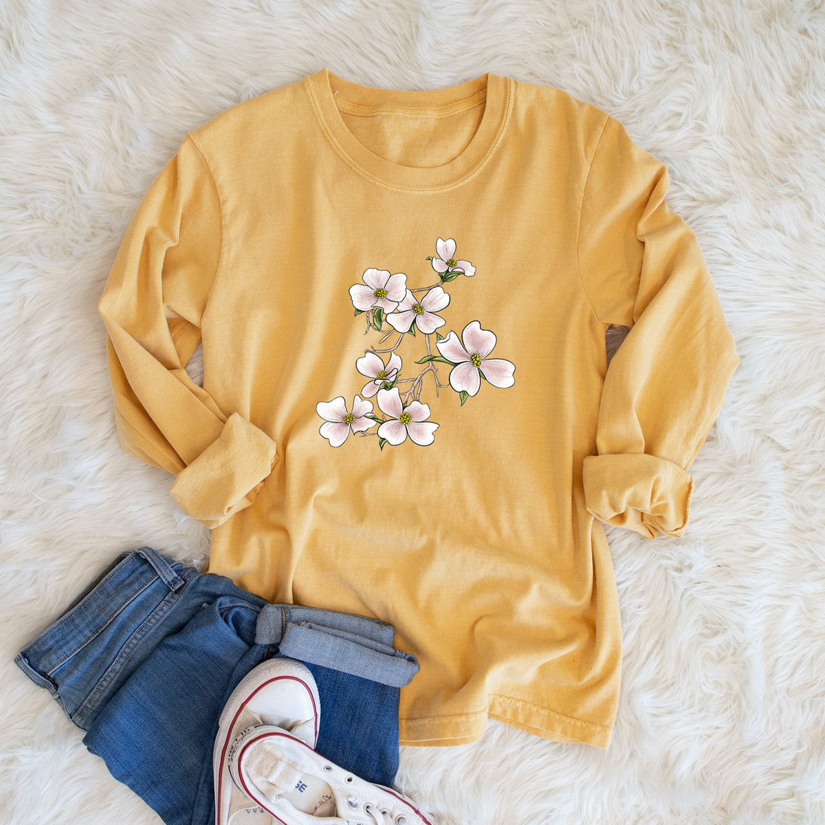 Golden wheat yellow Comfort Colors long sleeve shirt printed with a full-color illustration of pink and white dogwood blossoms on a branch, shown in a lifestyle photo.