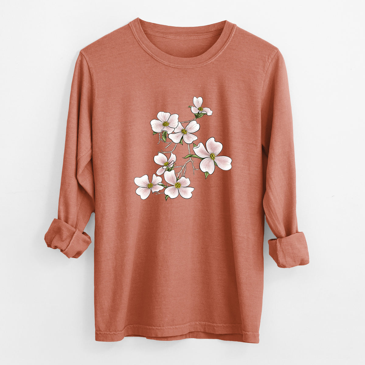 Yam burnt orange Comfort Colors long sleeve shirt laid flat with the cuffs rolled, printed with a full-color illustration of pink and white dogwood blossoms on a branch.