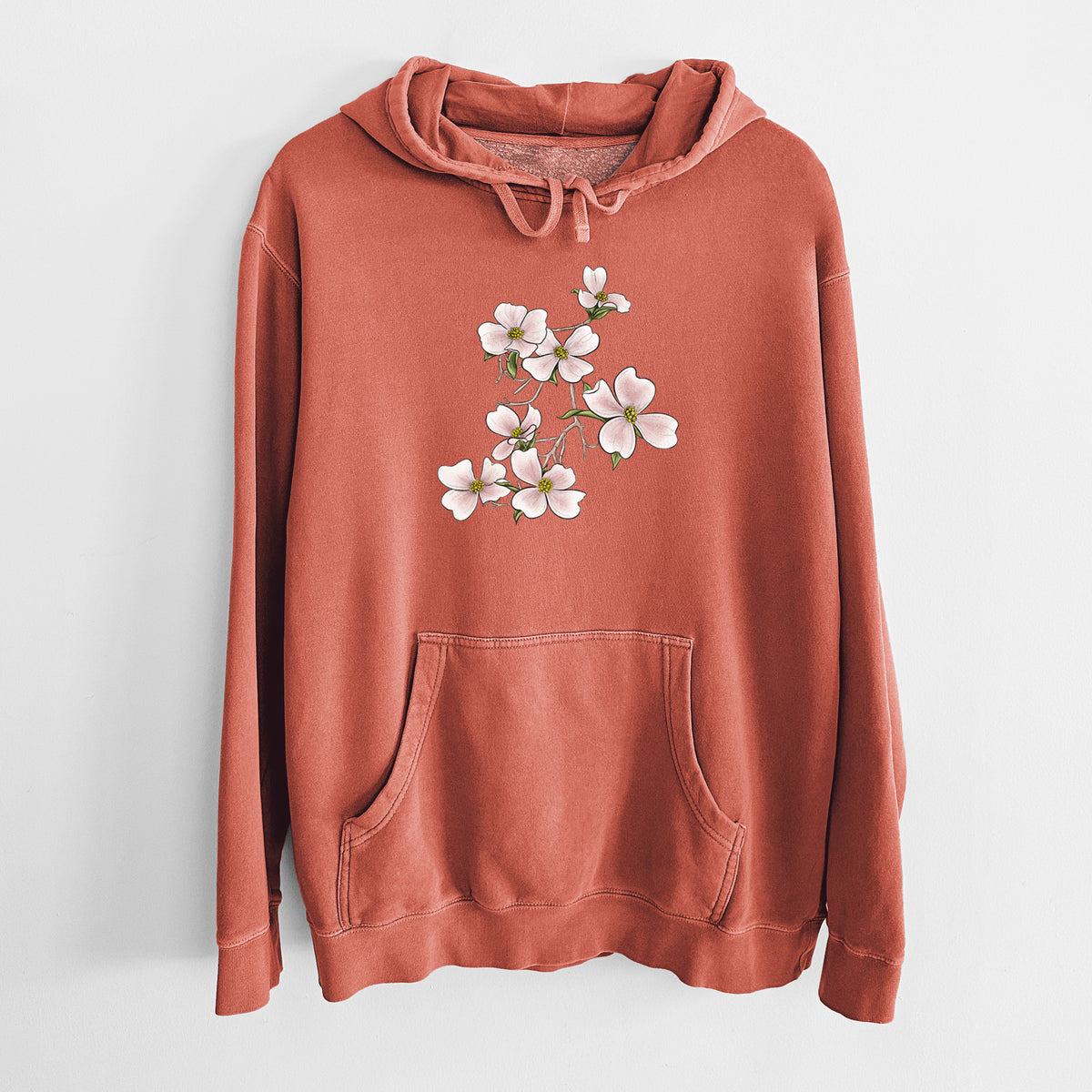 Amber orange pigment dyed hoodie laid flat, printed with a full-color illustration of pink and white dogwood blossoms on a branch.