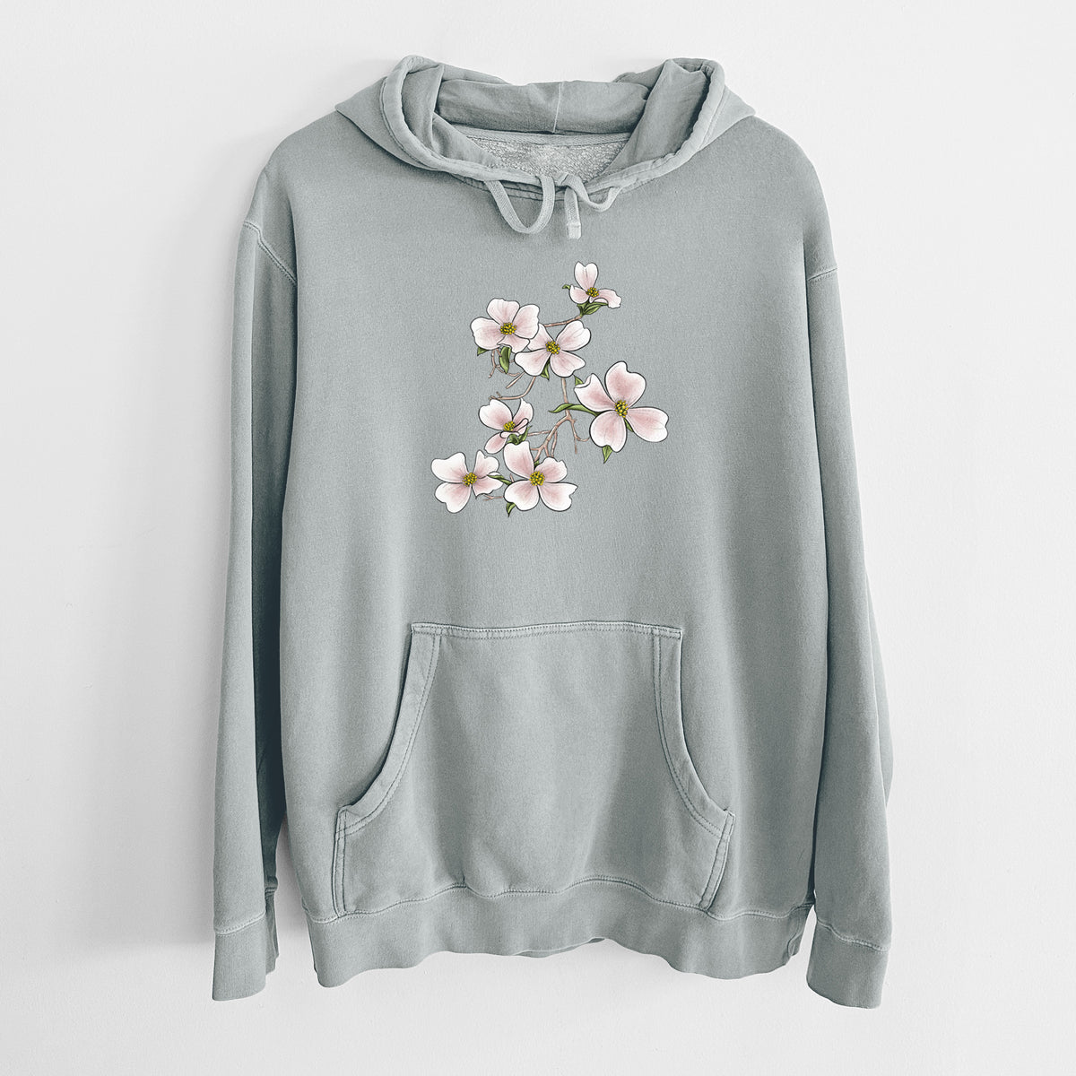 Sage green pigment dyed hoodie laid flat, printed with a full-color illustration of pink and white dogwood blossoms on a branch.
