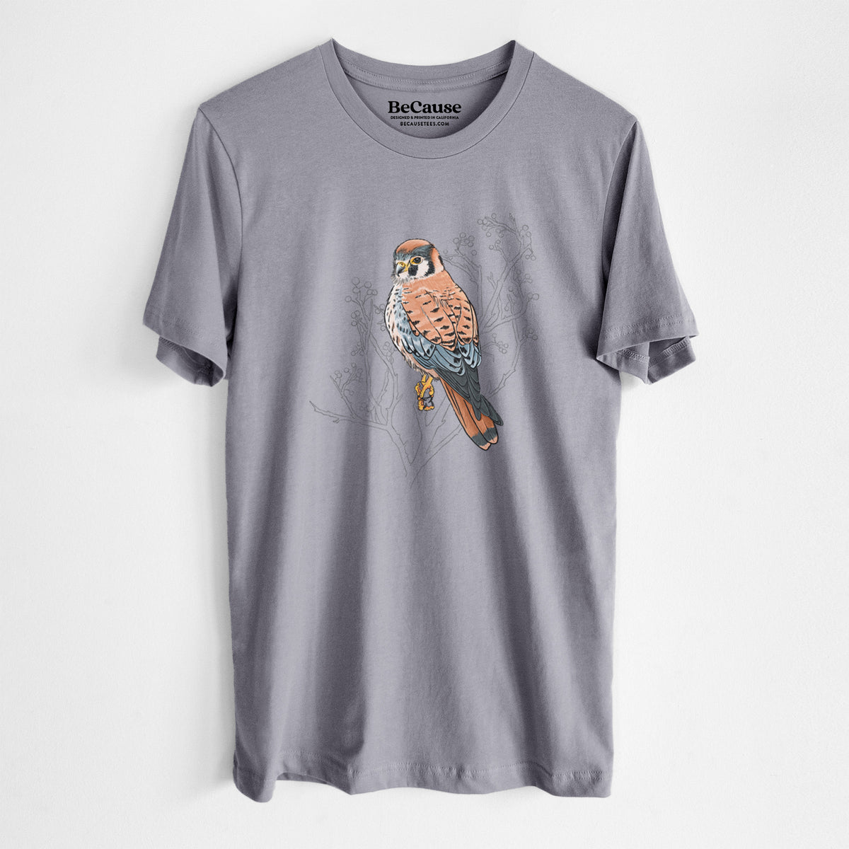Storm grey lightweight cotton t-shirt laid flat, printed with a full-color illustration of an American kestrel perched among pale branches.