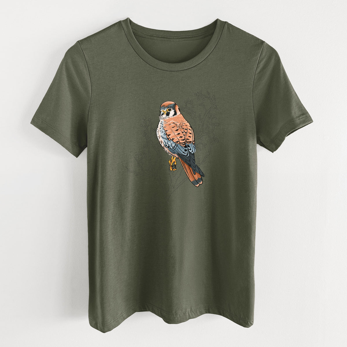 Military green women's relaxed fit cotton t-shirt laid flat, printed with a full-color illustration of an American kestrel perched among pale branches.