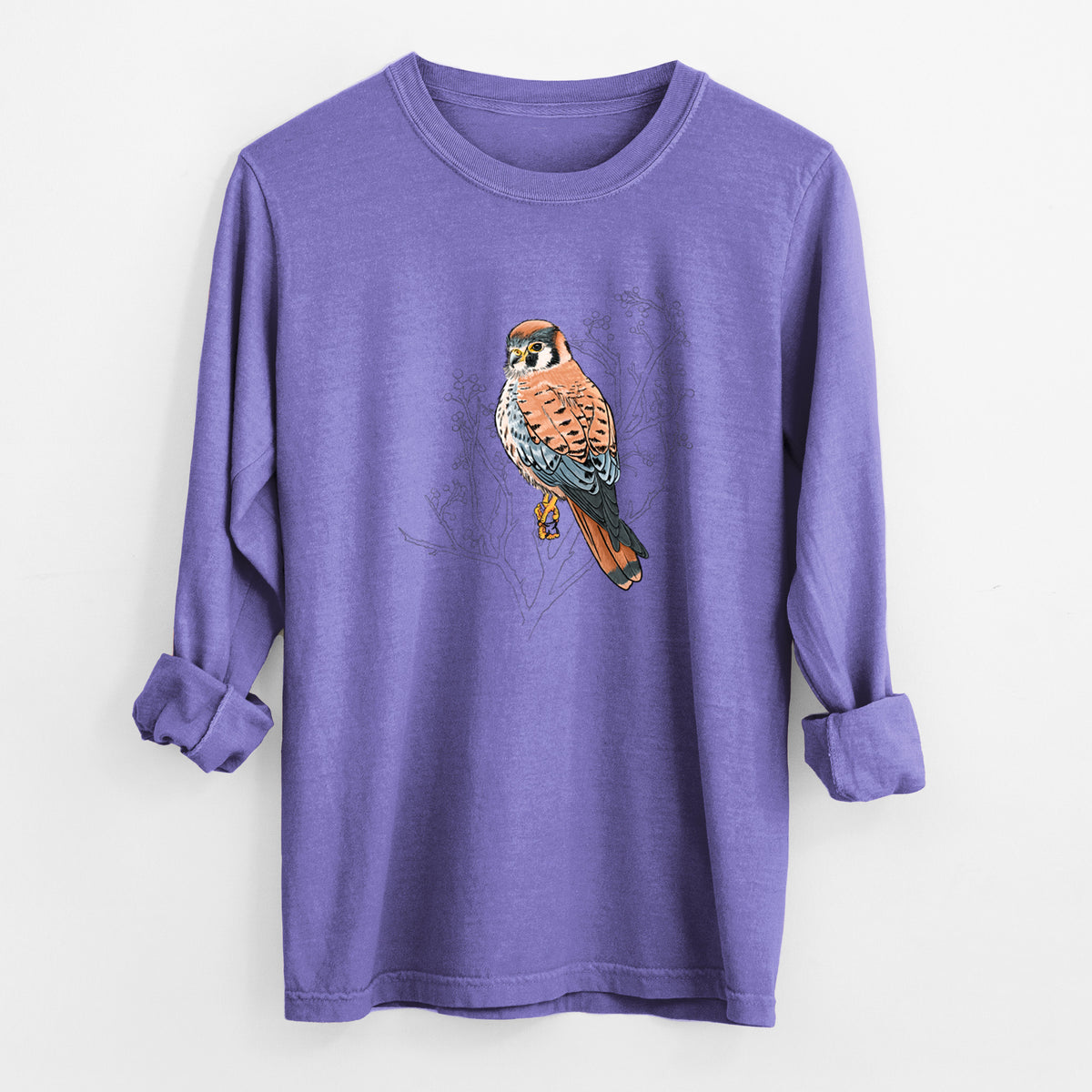 Violet purple Comfort Colors long sleeve shirt laid flat with the cuffs rolled, printed with a full-color illustration of an American kestrel perched among pale branches.