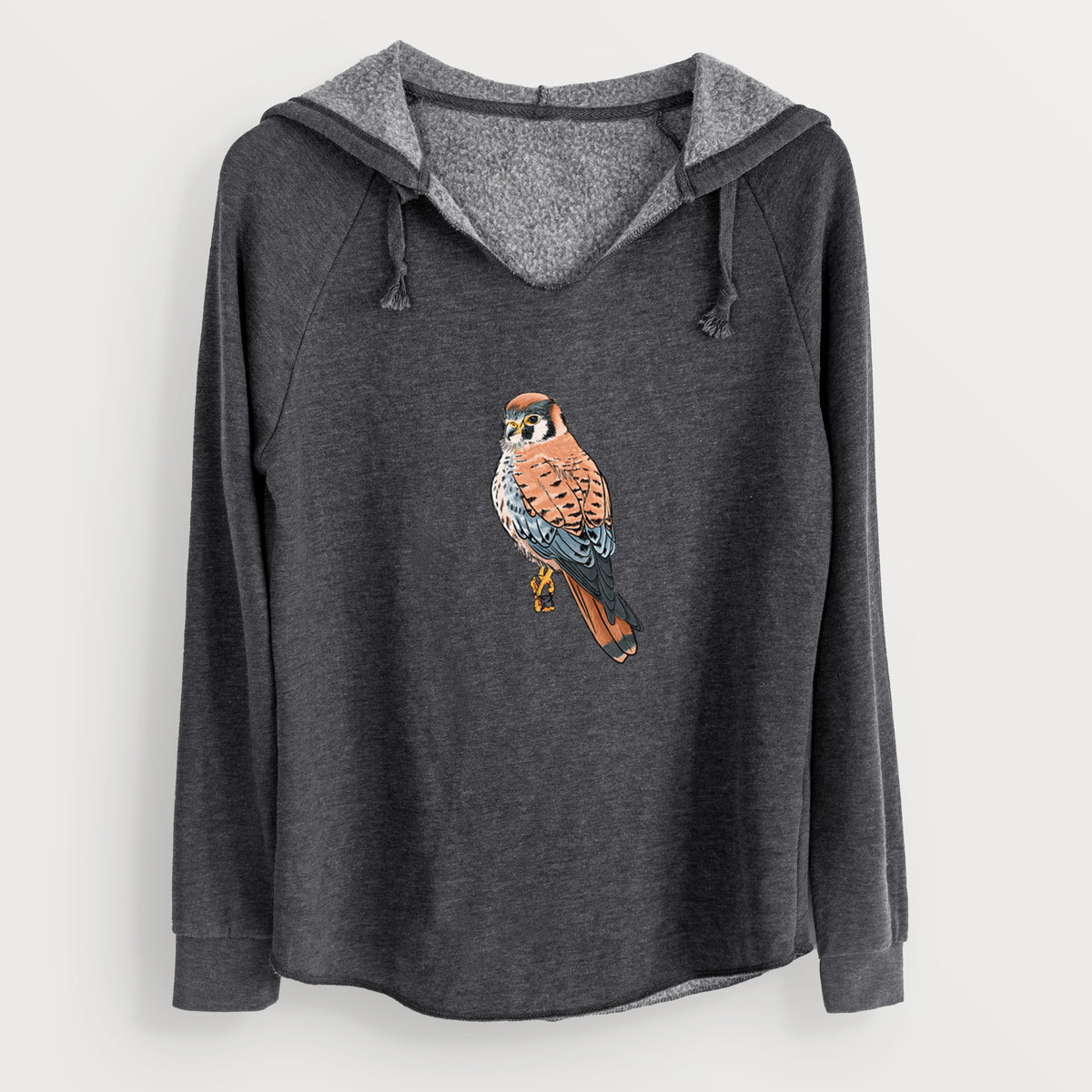 Charcoal grey women's Cali Wave hooded sweatshirt laid flat, printed with a full-color illustration of an American kestrel perched among pale branches.