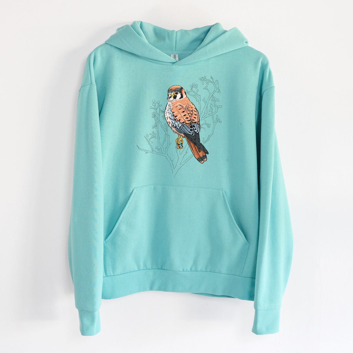 Vibrant American Kestrel - Falco sparverius - Statement Midweight Hoodie in Seafoam, hanging on a white wall, with a front kangaroo pocket and no drawcords.