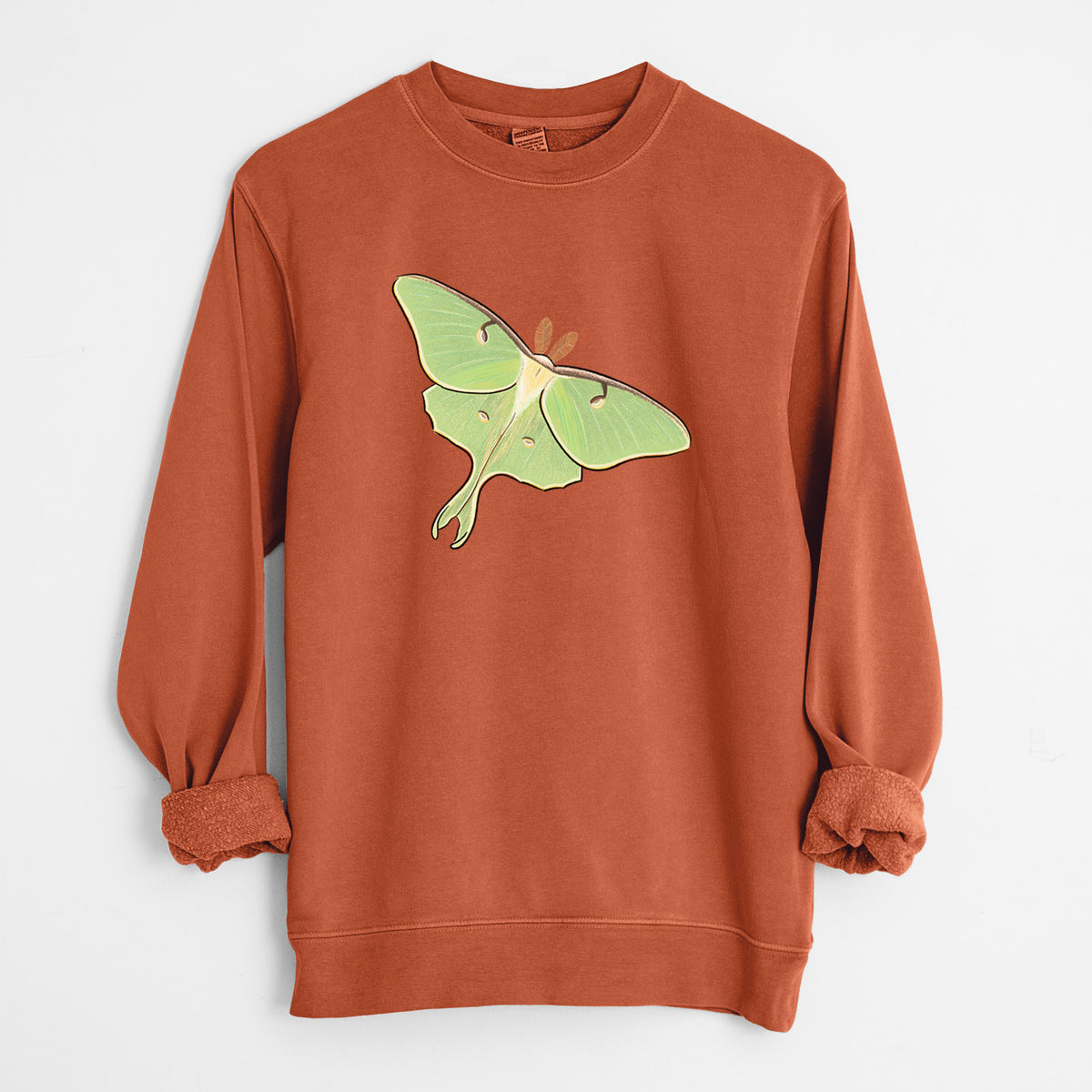 Amber orange pigment dyed crewneck sweatshirt laid flat with the sleeves rolled, printed with a full-color illustration of a pale green luna moth with long tails on its wings.