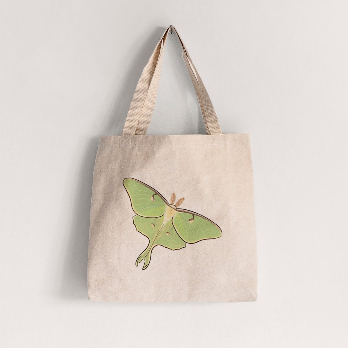 Natural canvas tote bag printed with a full-color illustration of a pale green luna moth with long tails on its wings.