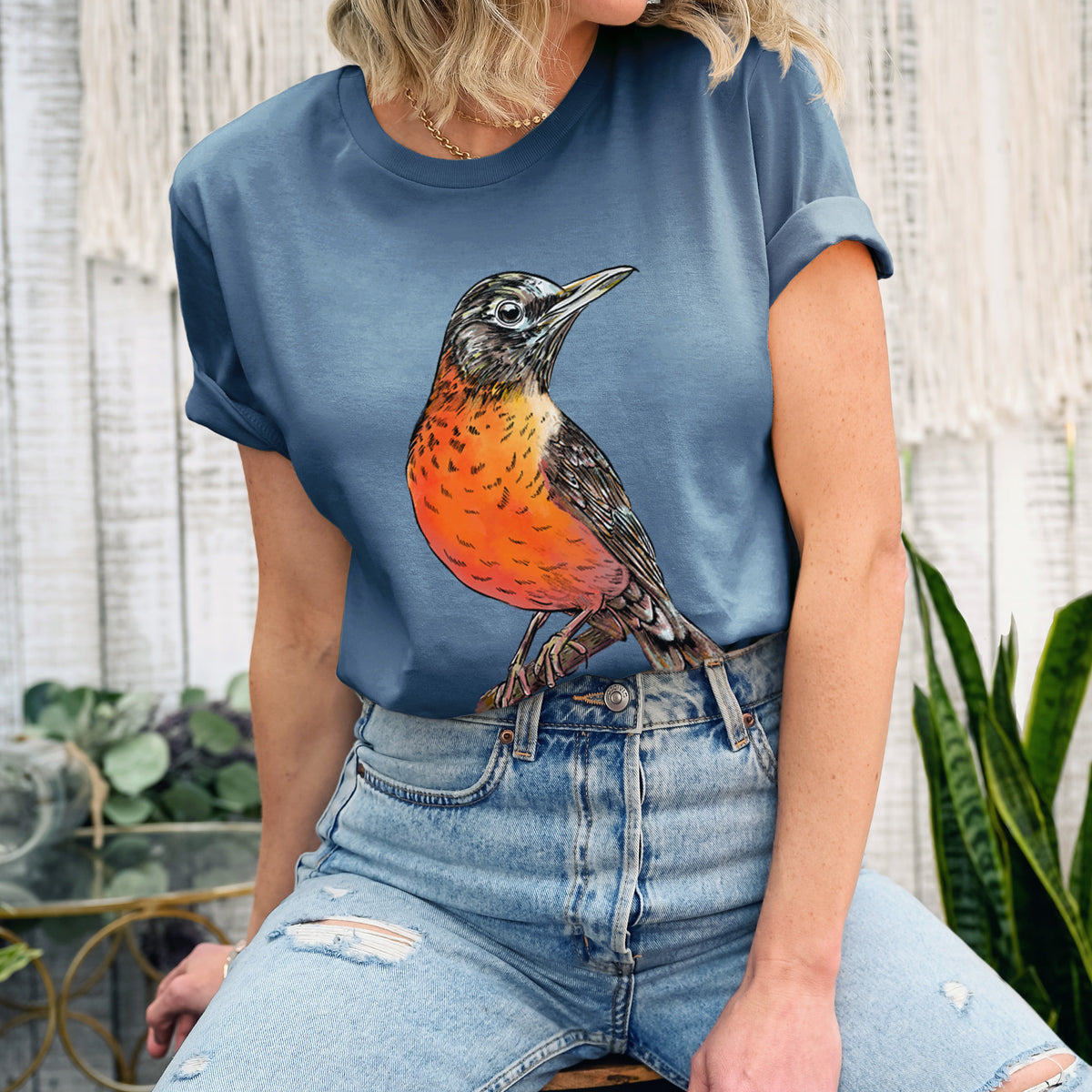 Woman wearing a steel blue lightweight cotton t-shirt printed with a full-color illustration of an American robin with an orange breast perched on a branch.