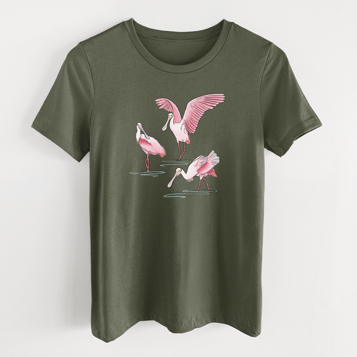 Military green women's relaxed fit cotton t-shirt laid flat, printed with a full-color illustration of three pink roseate spoonbills wading, one with its wings spread.