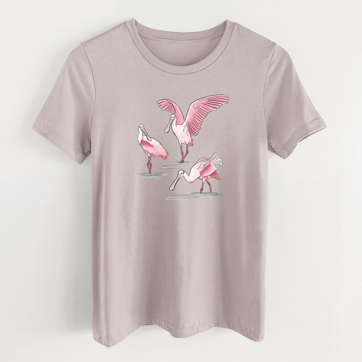 Pink gravel women's relaxed fit cotton t-shirt laid flat, printed with a full-color illustration of three pink roseate spoonbills wading, one with its wings spread.
