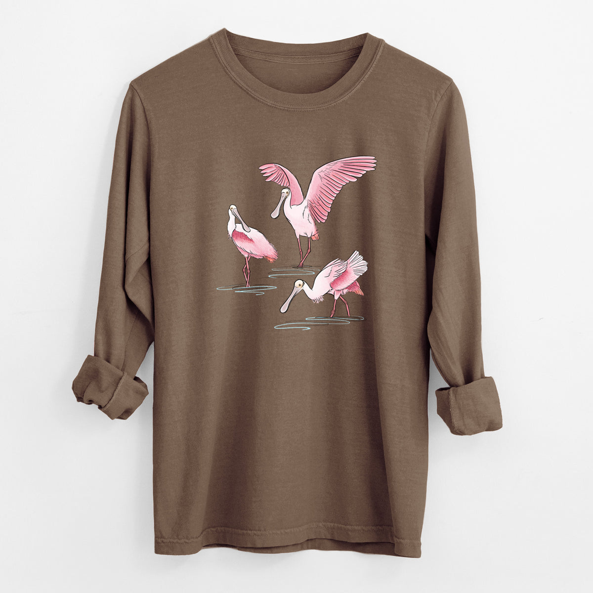 Espresso brown Comfort Colors long sleeve shirt laid flat with the cuffs rolled, printed with a full-color illustration of three pink roseate spoonbills wading, one with its wings spread.