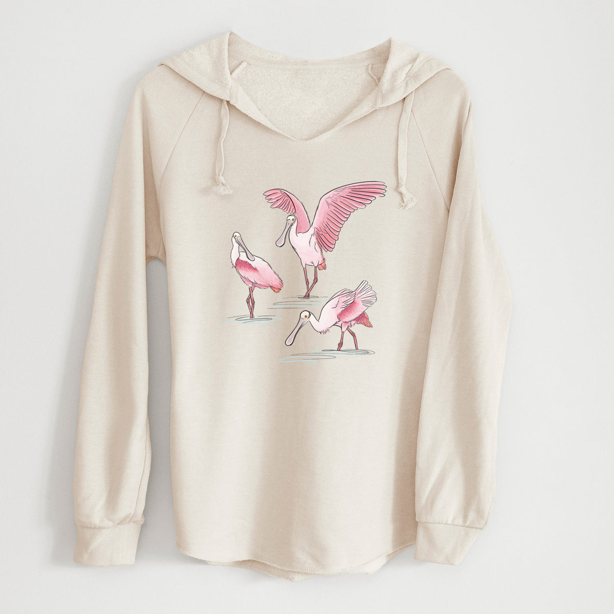 Bone cream women's Cali Wave hooded sweatshirt laid flat, printed with a full-color illustration of three pink roseate spoonbills wading, one with its wings spread.