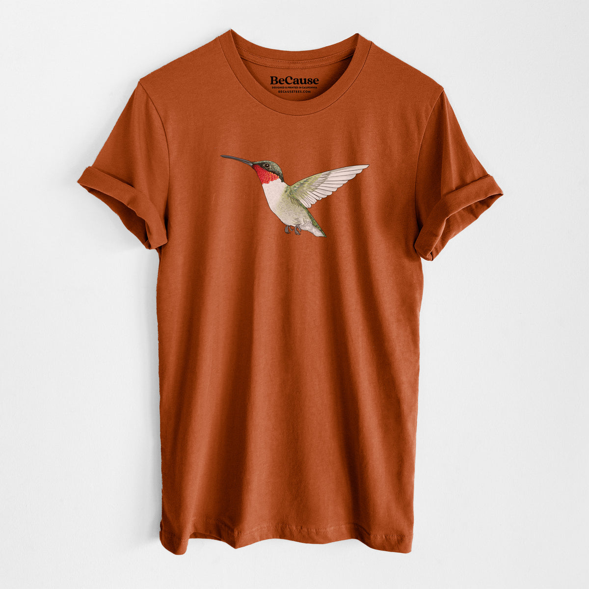Autumn lightweight cotton t-shirt laid flat, printed with a full-color illustration of a ruby-throated hummingbird in flight.