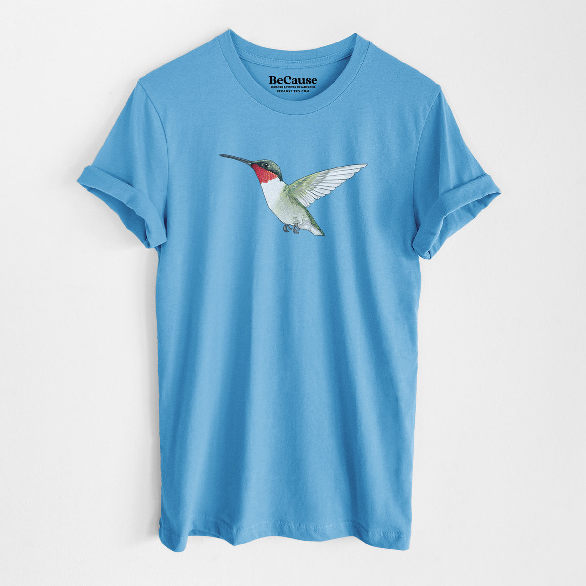 Ocean blue lightweight cotton t-shirt laid flat, printed with a full-color illustration of a ruby-throated hummingbird in flight.