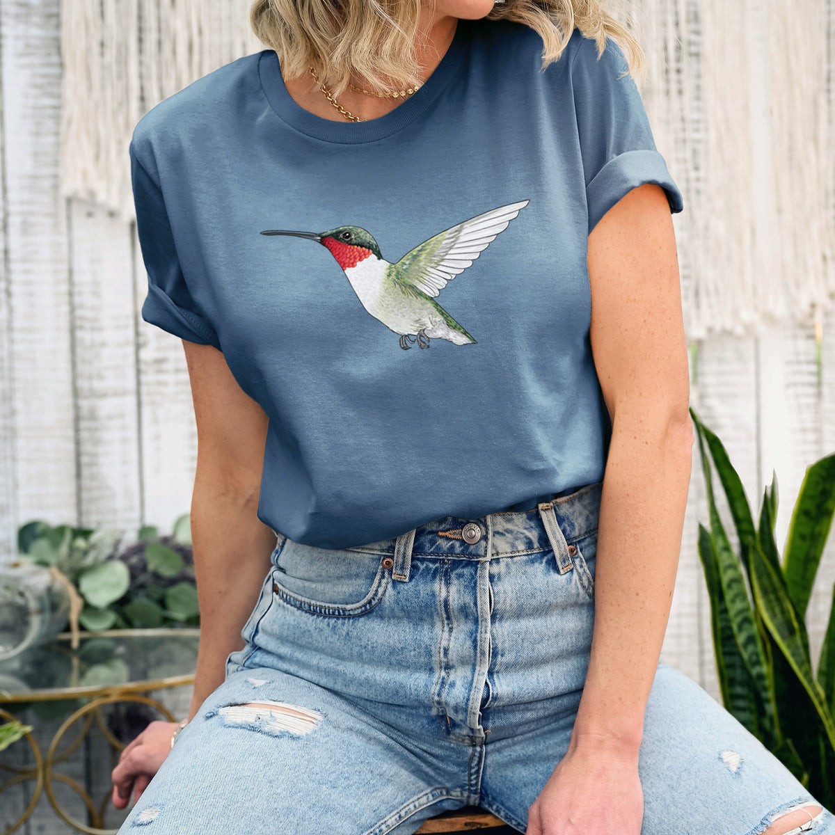 Woman wearing a steel blue lightweight cotton t-shirt printed with a full-color illustration of a ruby-throated hummingbird in flight.