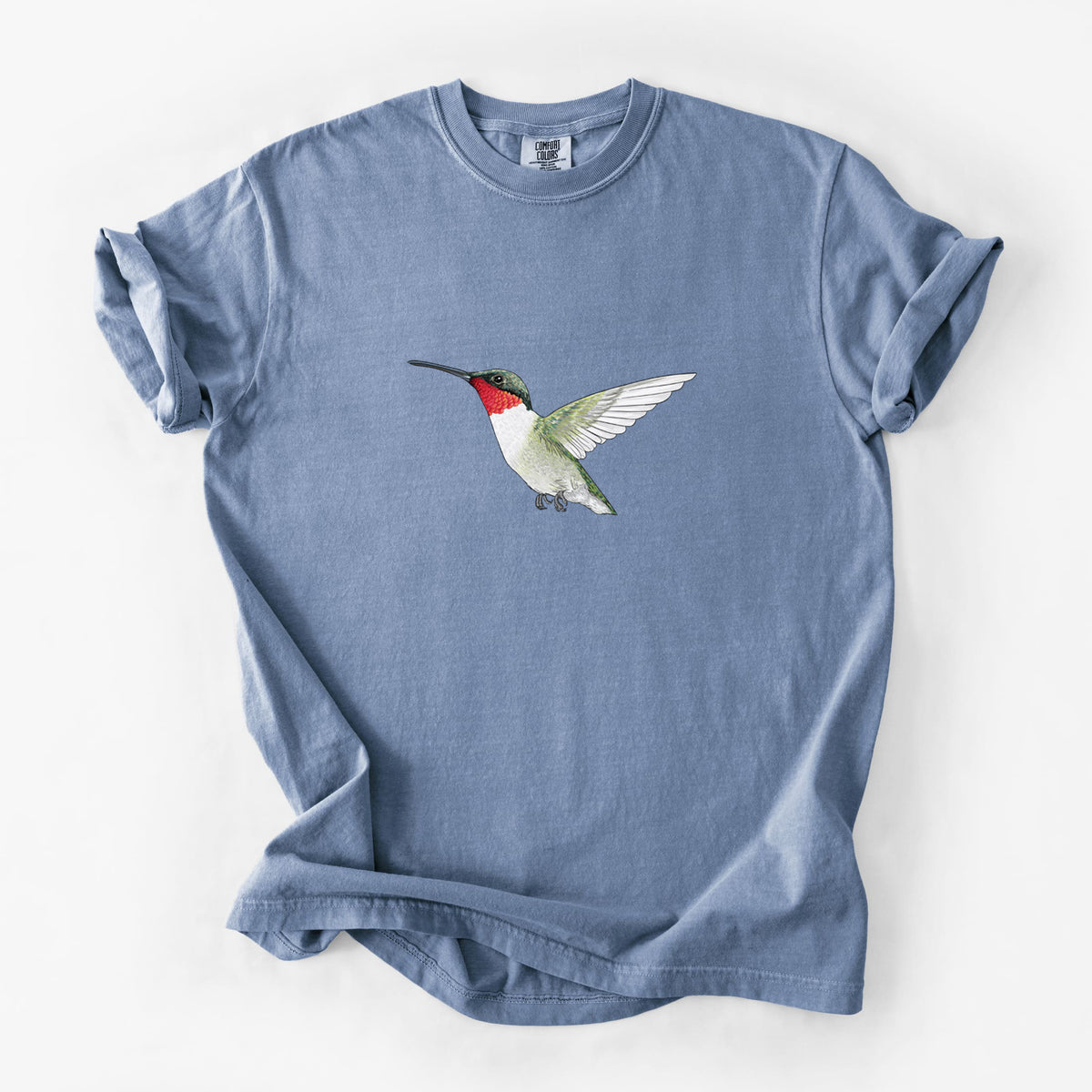 Blue jean Comfort Colors t-shirt laid flat, printed with a full-color illustration of a ruby-throated hummingbird in flight.