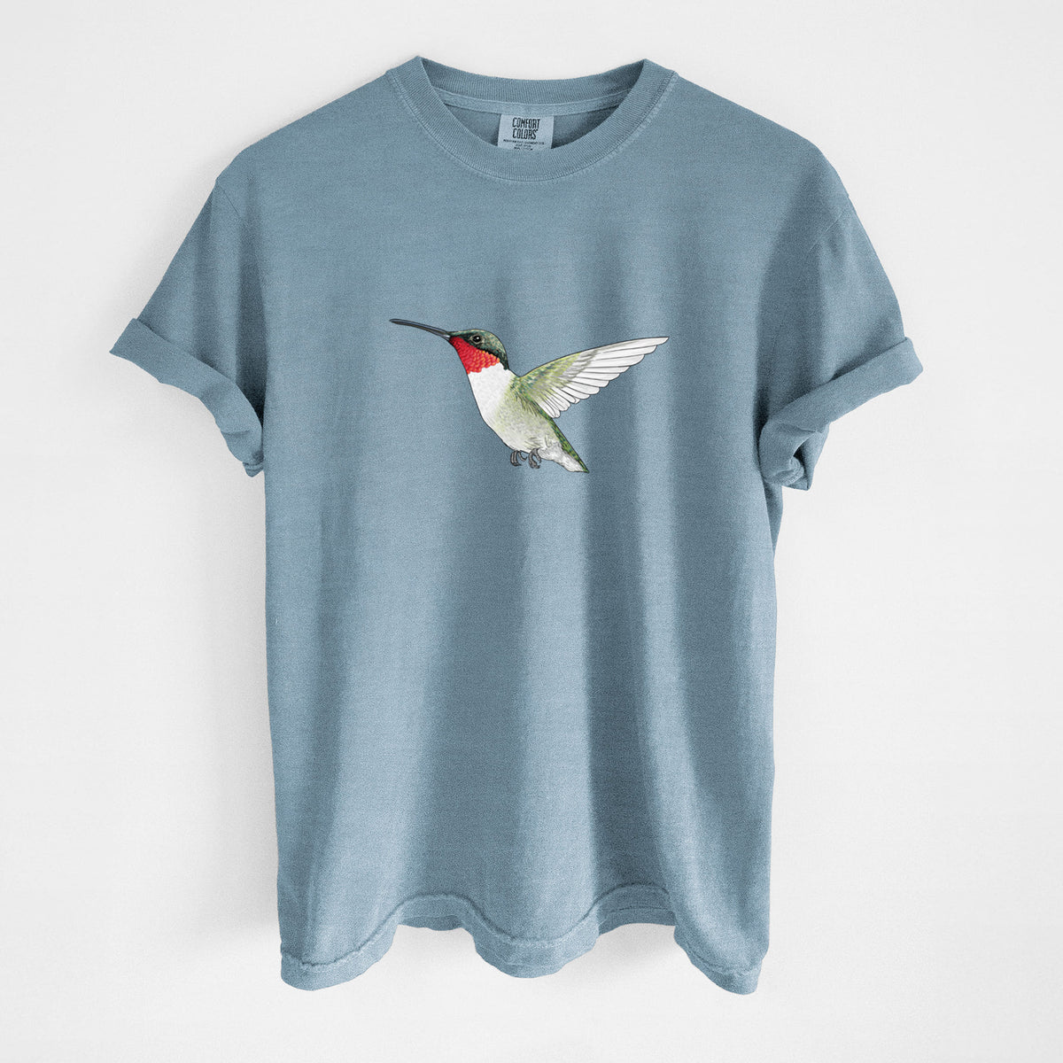 Steel blue Comfort Colors t-shirt laid flat, printed with a full-color illustration of a ruby-throated hummingbird in flight.