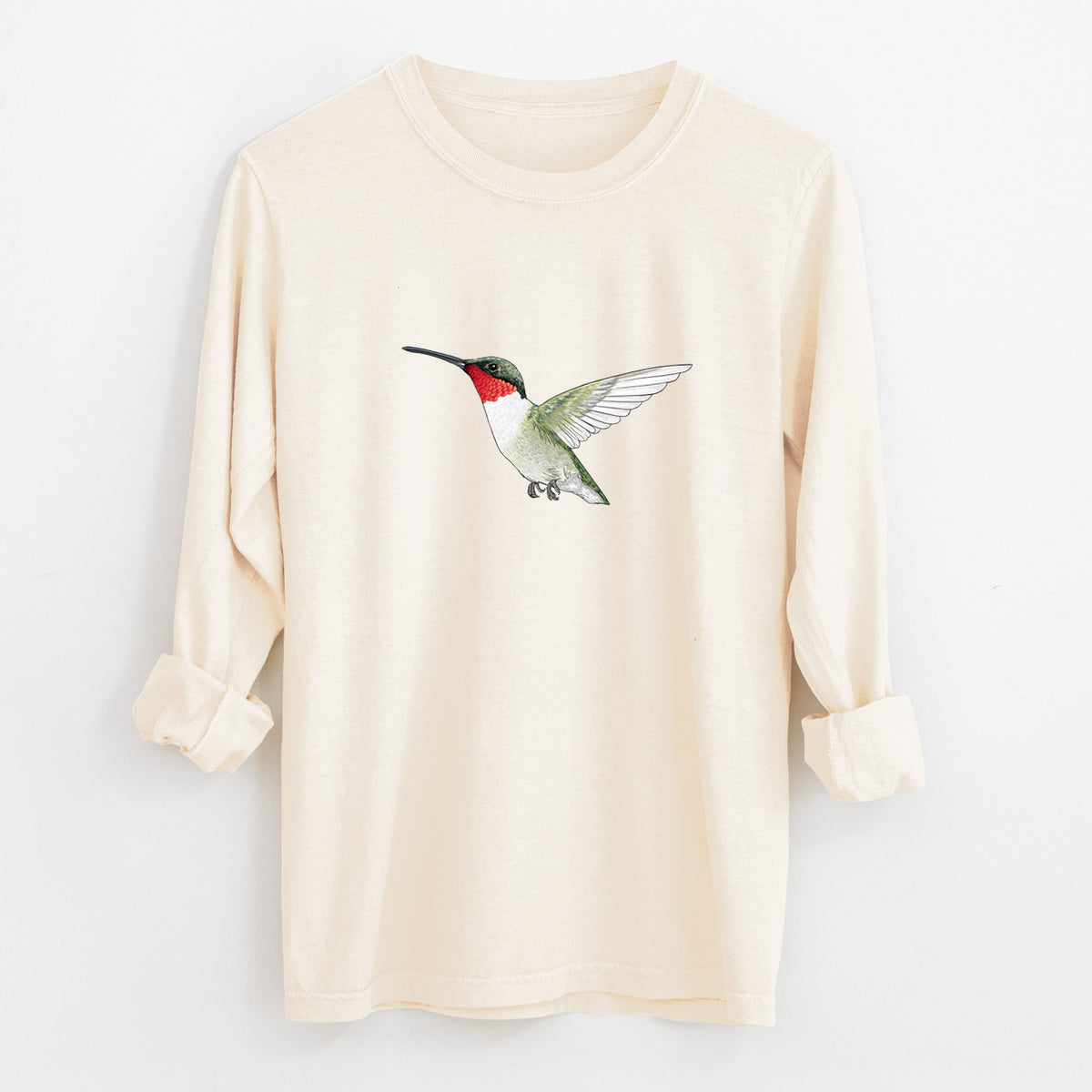 Ivory Comfort Colors long sleeve shirt laid flat with the cuffs rolled, printed with a full-color illustration of a ruby-throated hummingbird in flight.