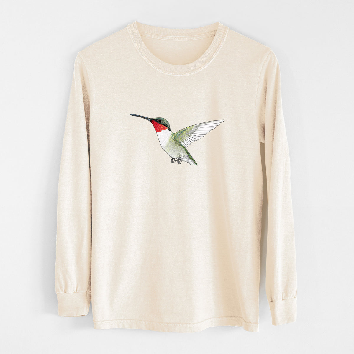 Ivory Comfort Colors long sleeve shirt laid flat, printed with a full-color illustration of a ruby-throated hummingbird in flight.