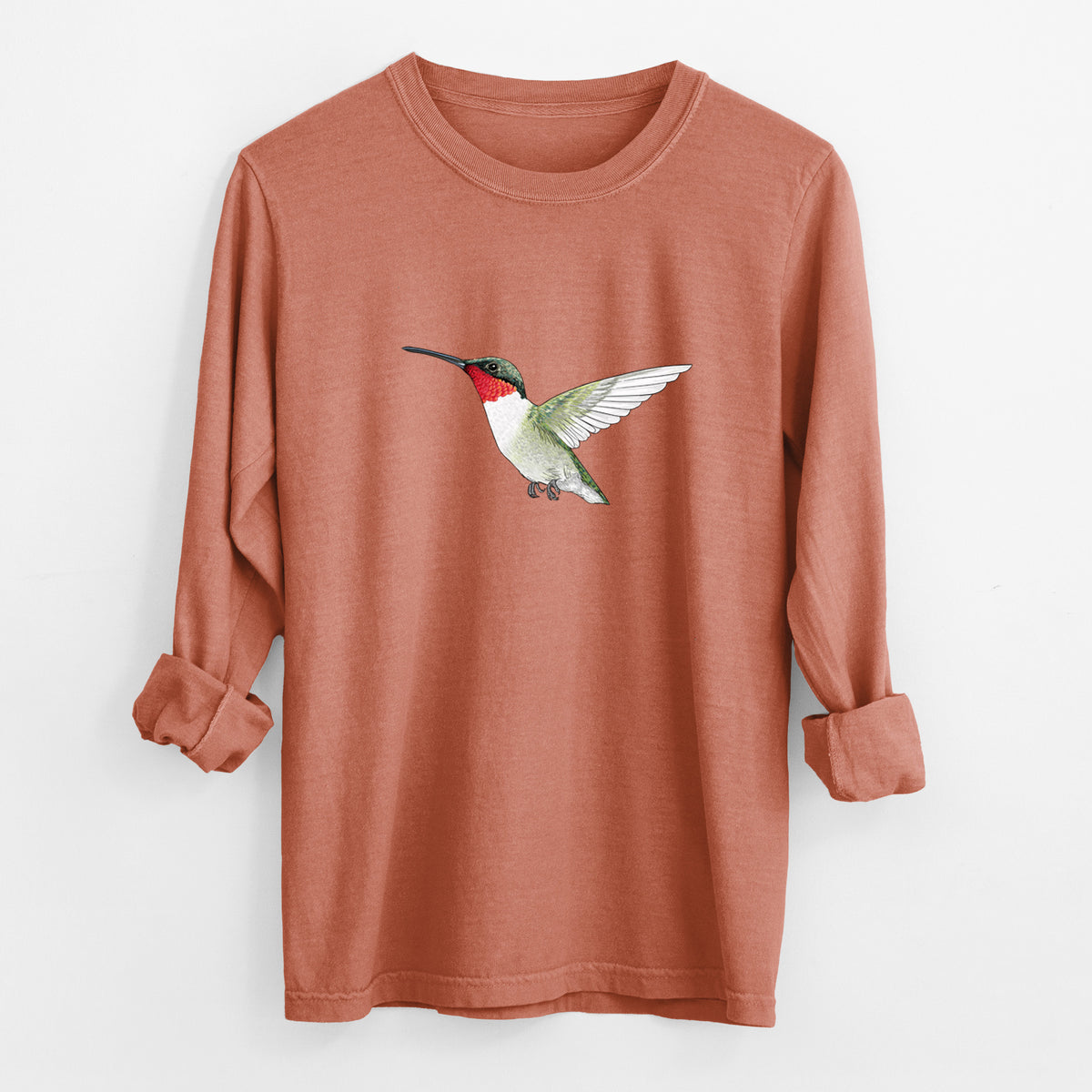 Yam burnt orange Comfort Colors long sleeve shirt laid flat with the cuffs rolled, printed with a full-color illustration of a ruby-throated hummingbird in flight.