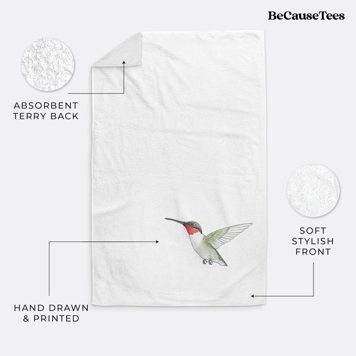 White hand towel printed with a full-color illustration of a ruby-throated hummingbird in flight.